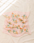 Leto Collection orchid flower face mask with floral pattern, flat lay display showing vibrant design and breathable fabric.