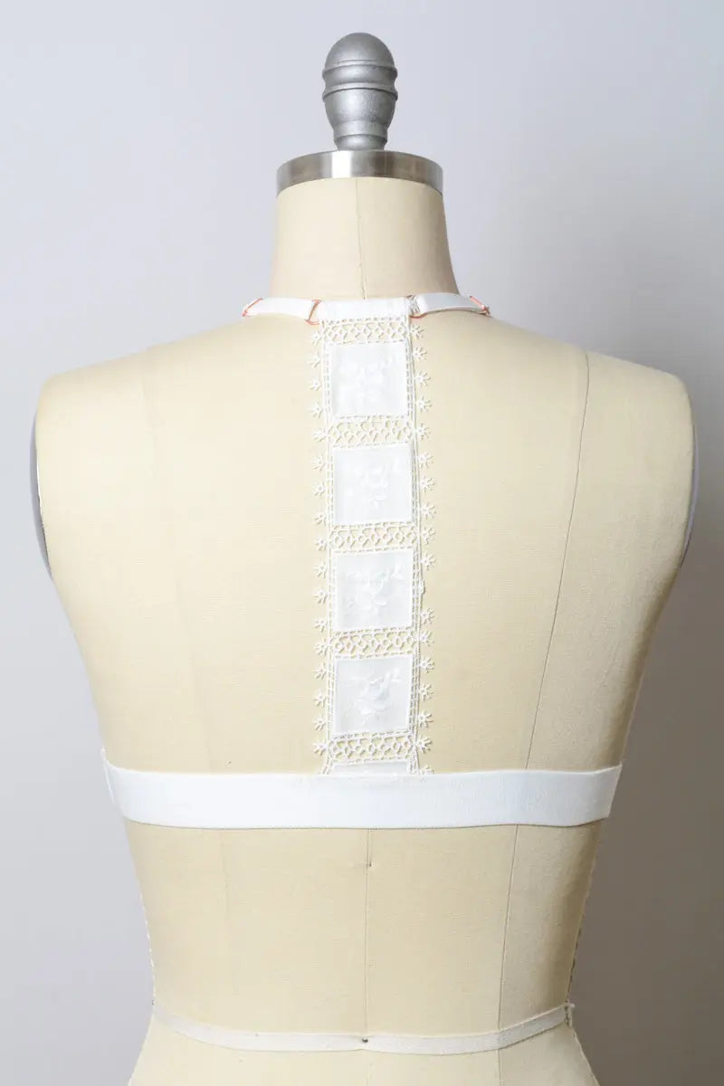 White crochet T-back bralette from Leto Collection with intricate lace detailing and comfortable fit.