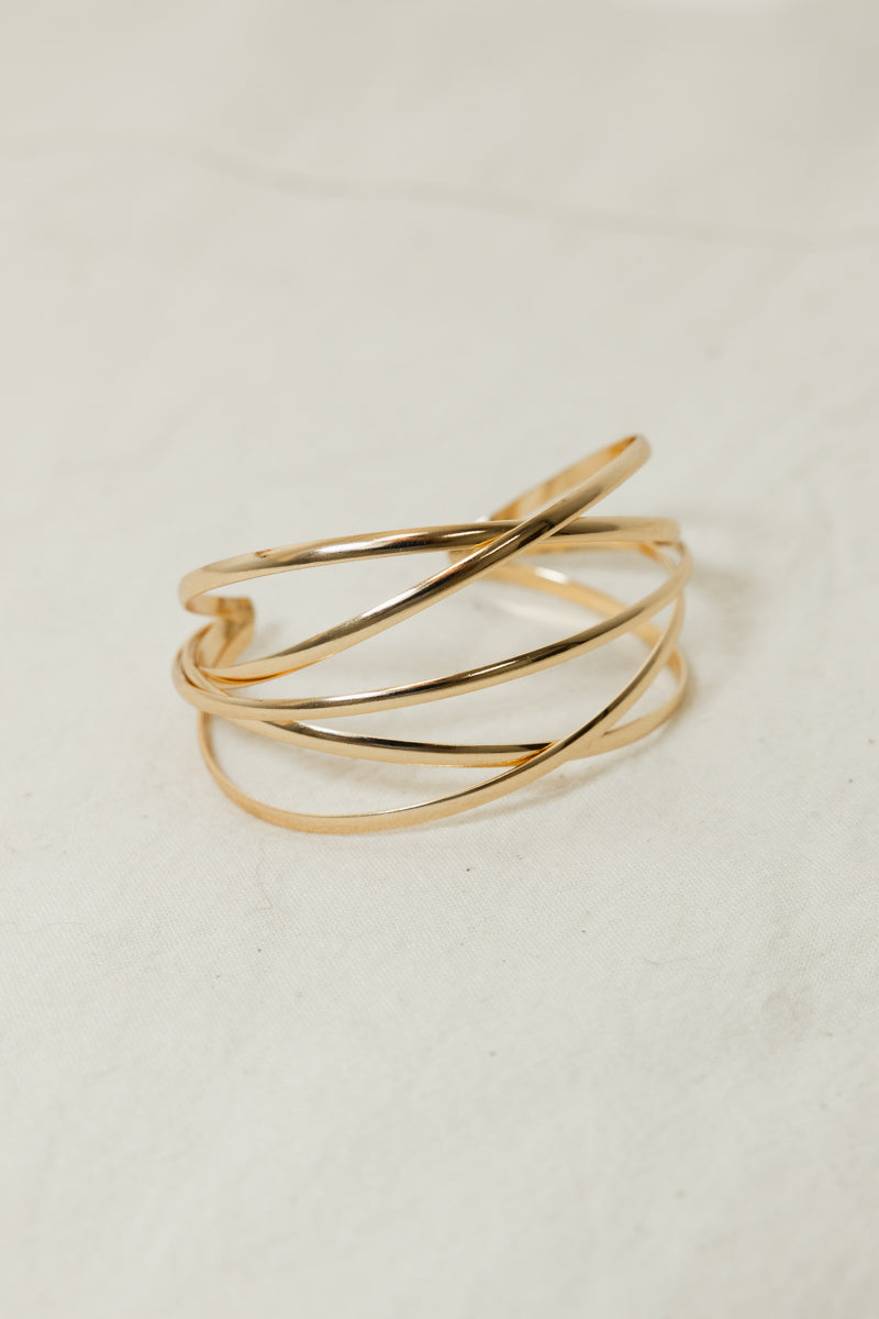 Adjustable metallic cuff gold armlet with a polished finish.