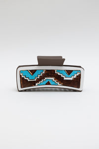 Geometric pattern hair claw clip with blue and brown design.