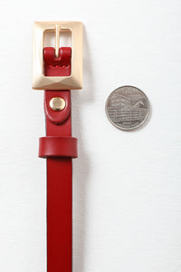 Gold buckle thin red belt for chic and elegant looks.