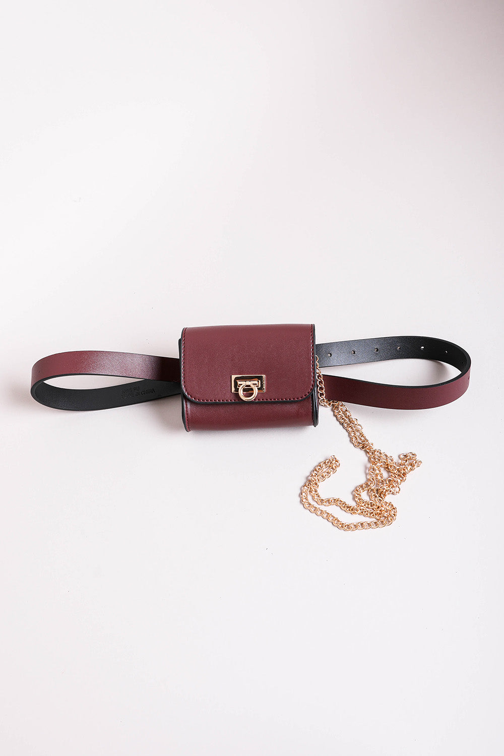 Mini faux burgundy leather belt bag with chic gold details.