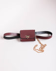 Mini faux burgundy leather belt bag with chic gold details.