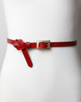 Narrow leather red belt with adjustable gold buckle detail.