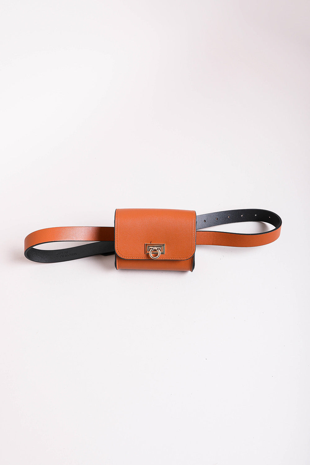 Versatile cognac faux leather mini bag with gold chain details.